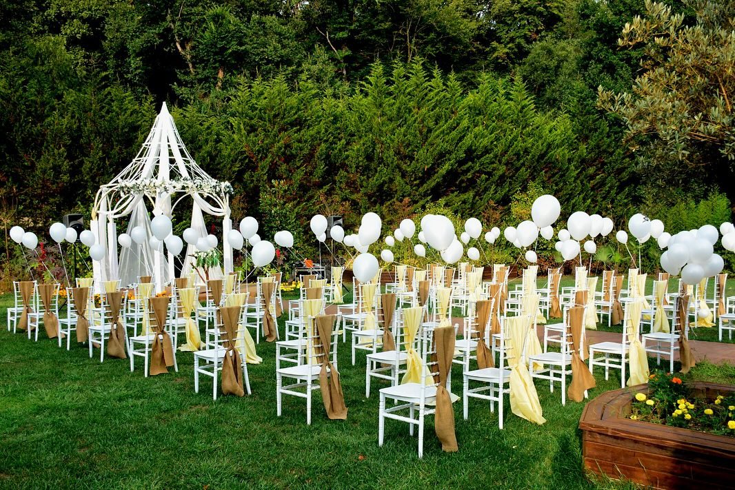 Çim alanda beyaz sandalyeli kır düğünü organizasyonu