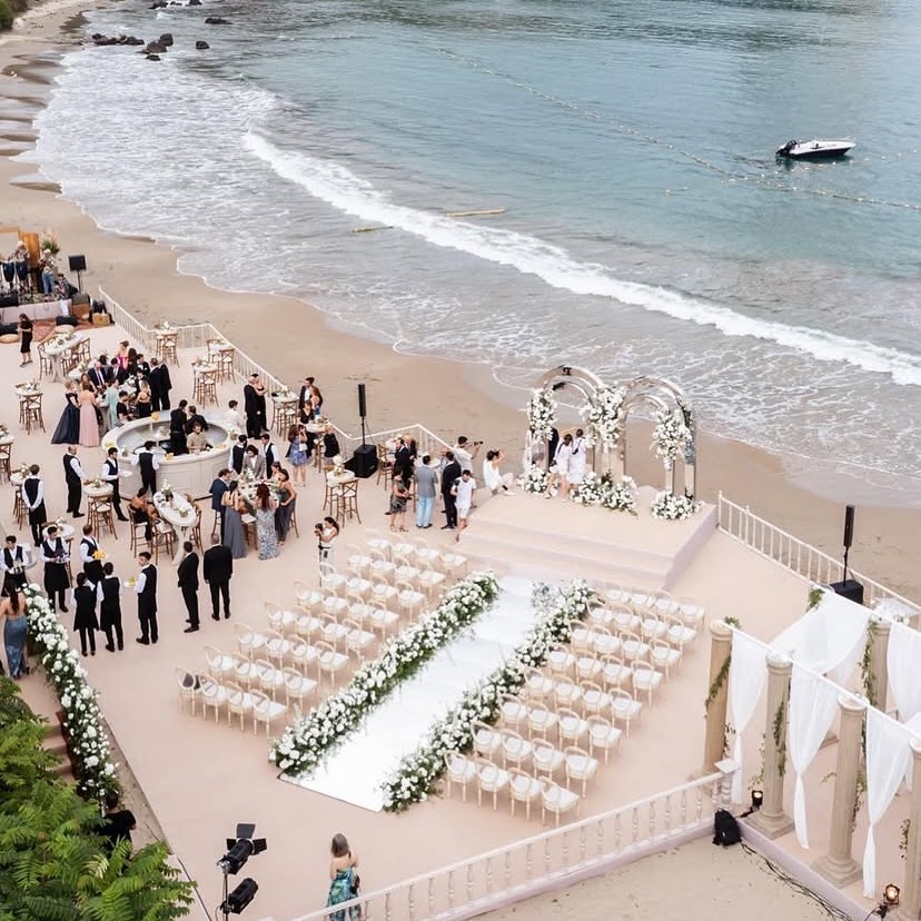 Deniz kenarında nikâh alanı ve beyaz sandalyeler