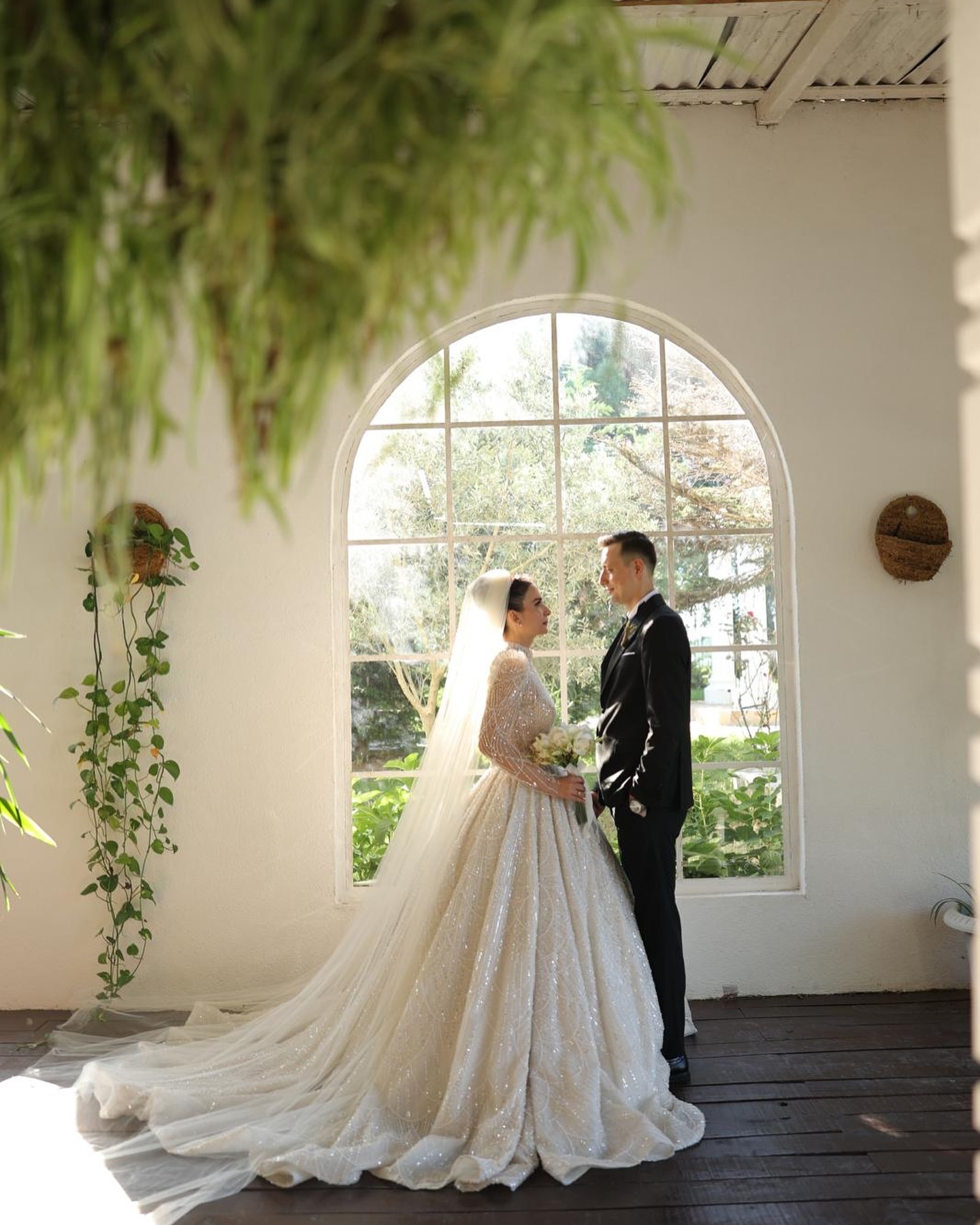 Büyük pencereli mekânda çift çekimi, Ceylan Güres Modaevi prenses gelinlik ve uzun duvak detayları