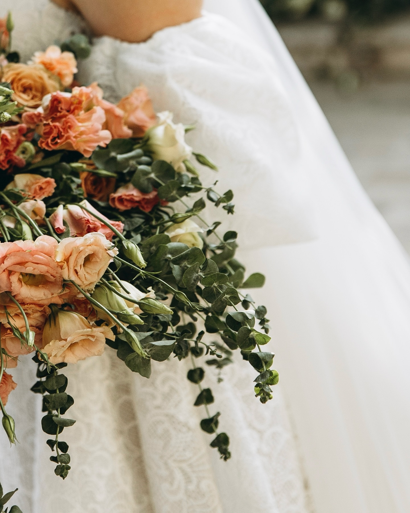 Dantel dokulu A kesim gelinliğin yakın plan etek ve çiçek buketi detay çekimi