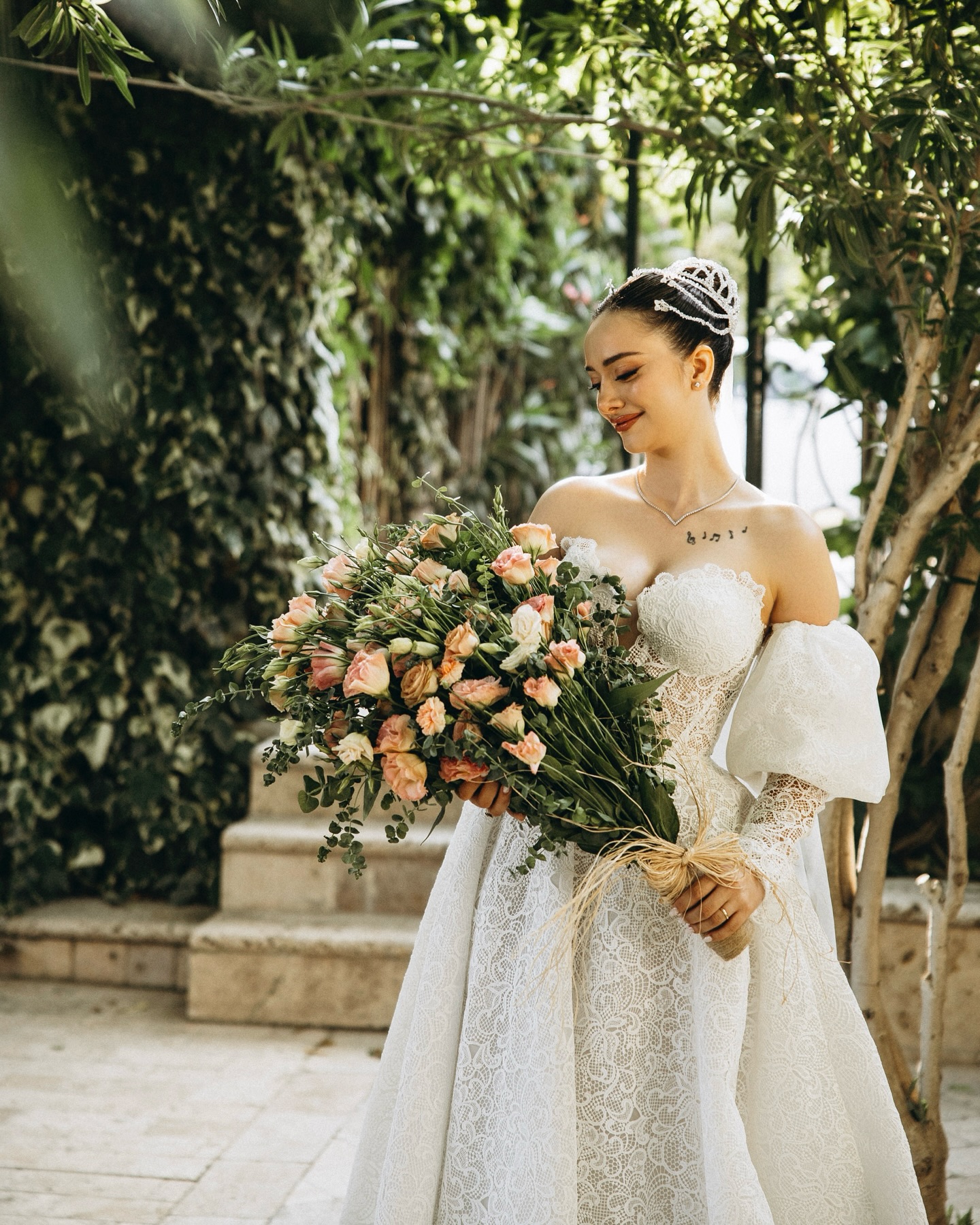 Bahçede romantik konseptte dantel A kesim gelinlik ile gelin portresi ve buket detayı