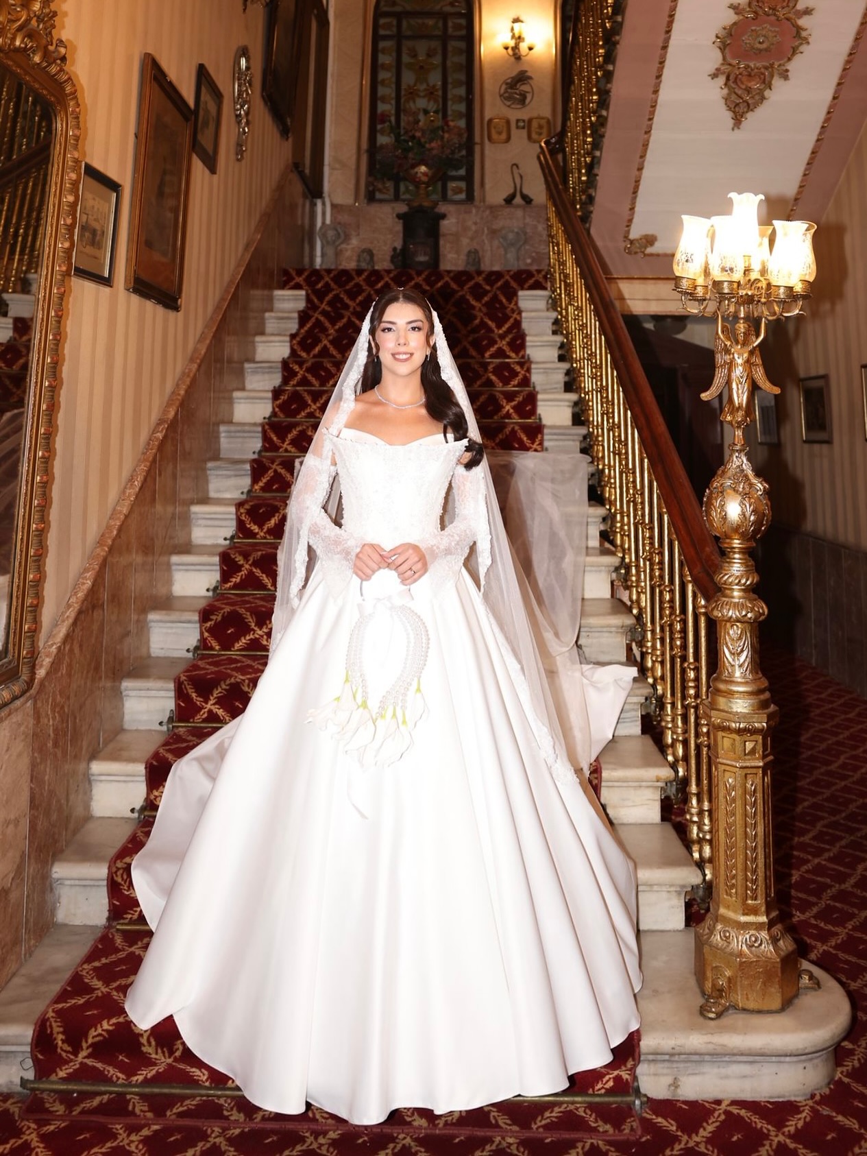 Esra Özcan imzalı ışıltılı işlemeli, düşük omuzlu prenses gelinlik modelinin önden görünümü ve hacimli eteği.