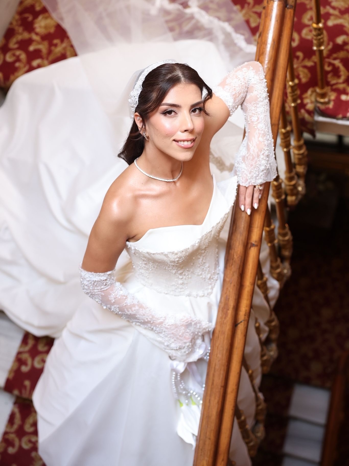  Siyah beyaz çekimde düşük omuzlu, tül kollu ve işlemeli gövdeli prenses gelinlik ile zarif poz.