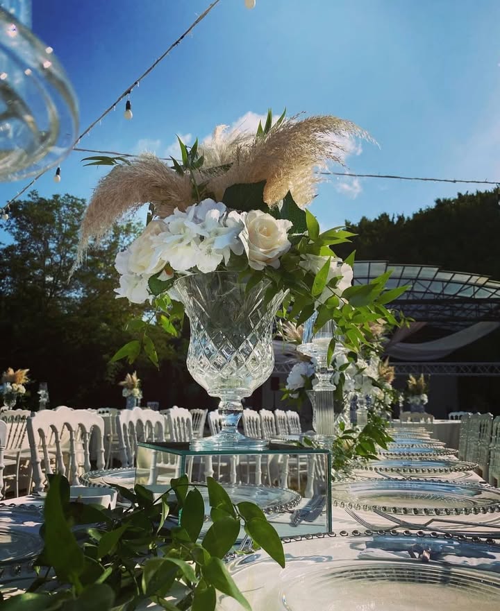 Cam suplalar ve pastel çiçeklerle rustik düğün masası