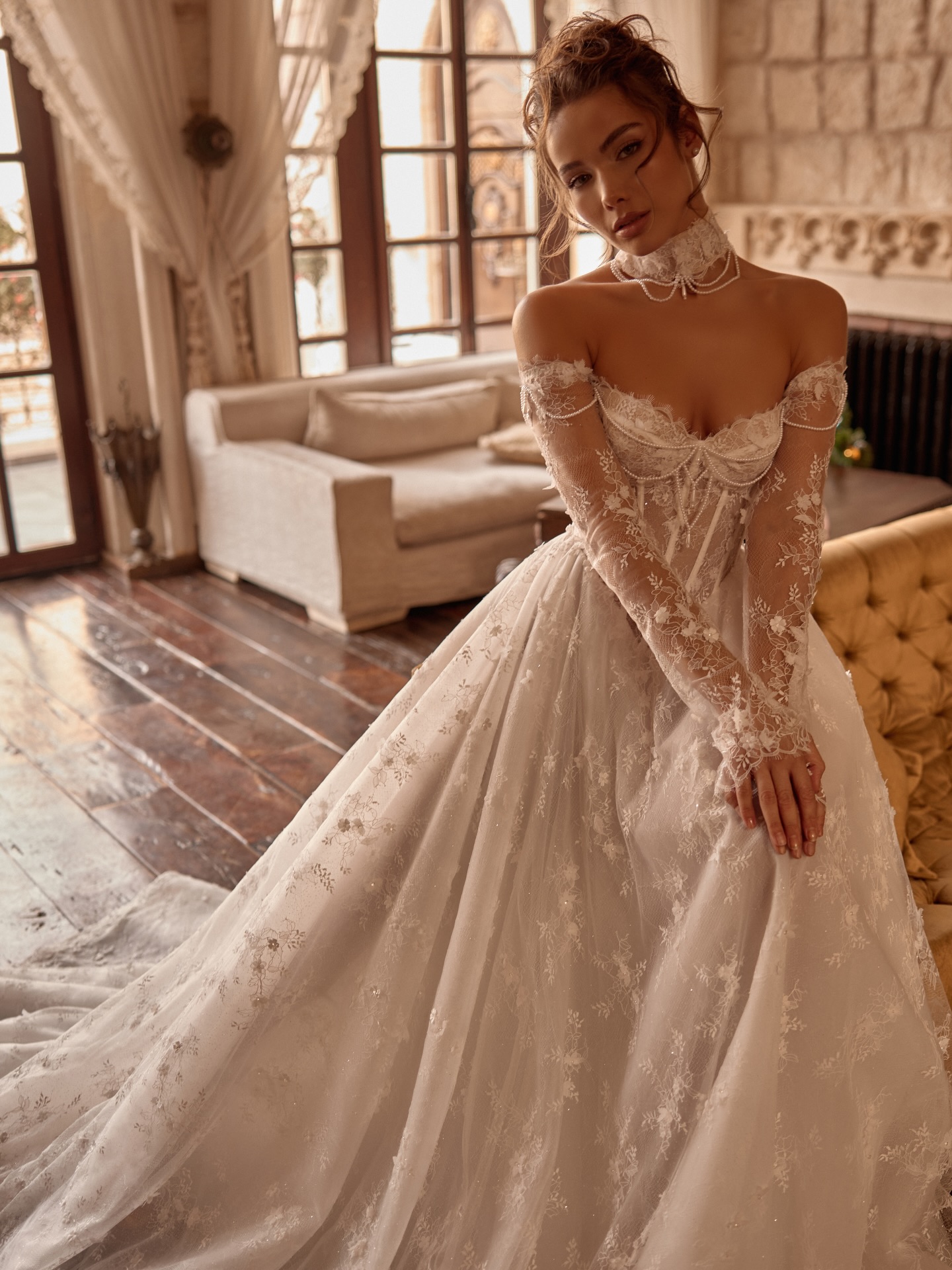 Dantel işlemeli uzun kollu, düşük omuzlu korseli gelinlik ile vintage dekorlu salonda romantik ve feminen gelin stili.