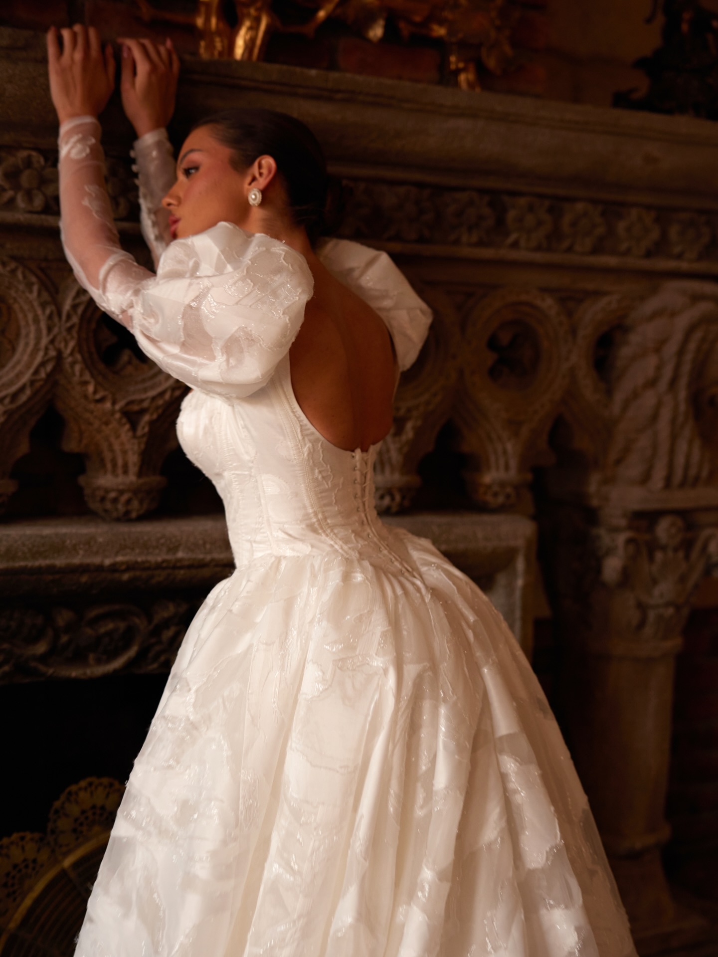 “Balon kollu prenses gelinlik modeli, açık sırt detayıyla tarihi mekânda romantik poz.”