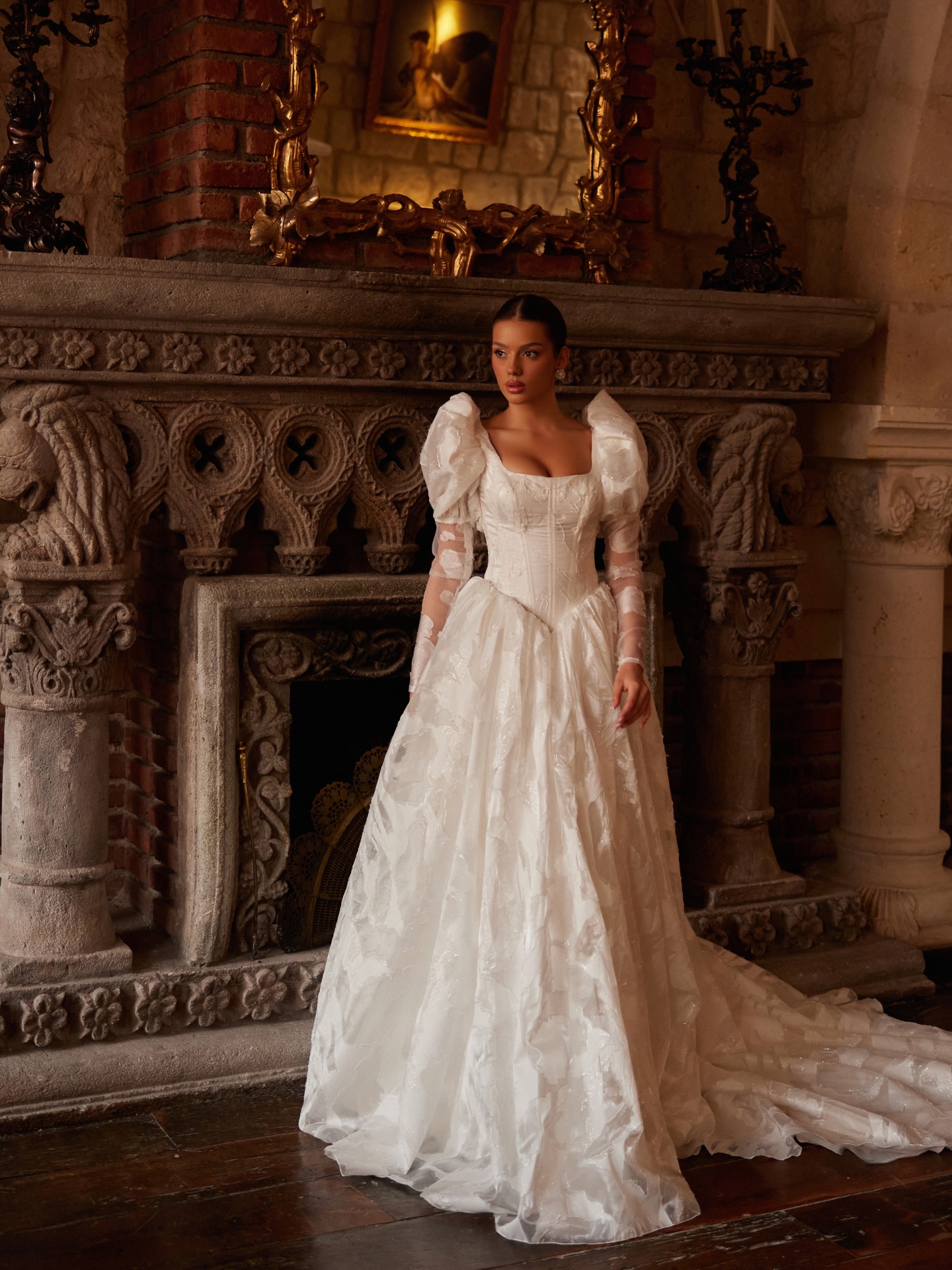 “Korse kesimli prenses gelinlik, kabartmalı doku ve zarif balon kol tasarımı.”