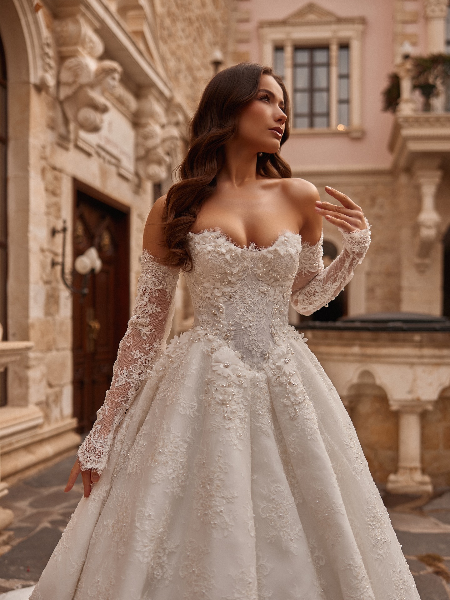 Kalp yaka düşük omuz prenses gelinlik modeli, işlemeli korsaj ve kabarık etek detayıyla şık poz.