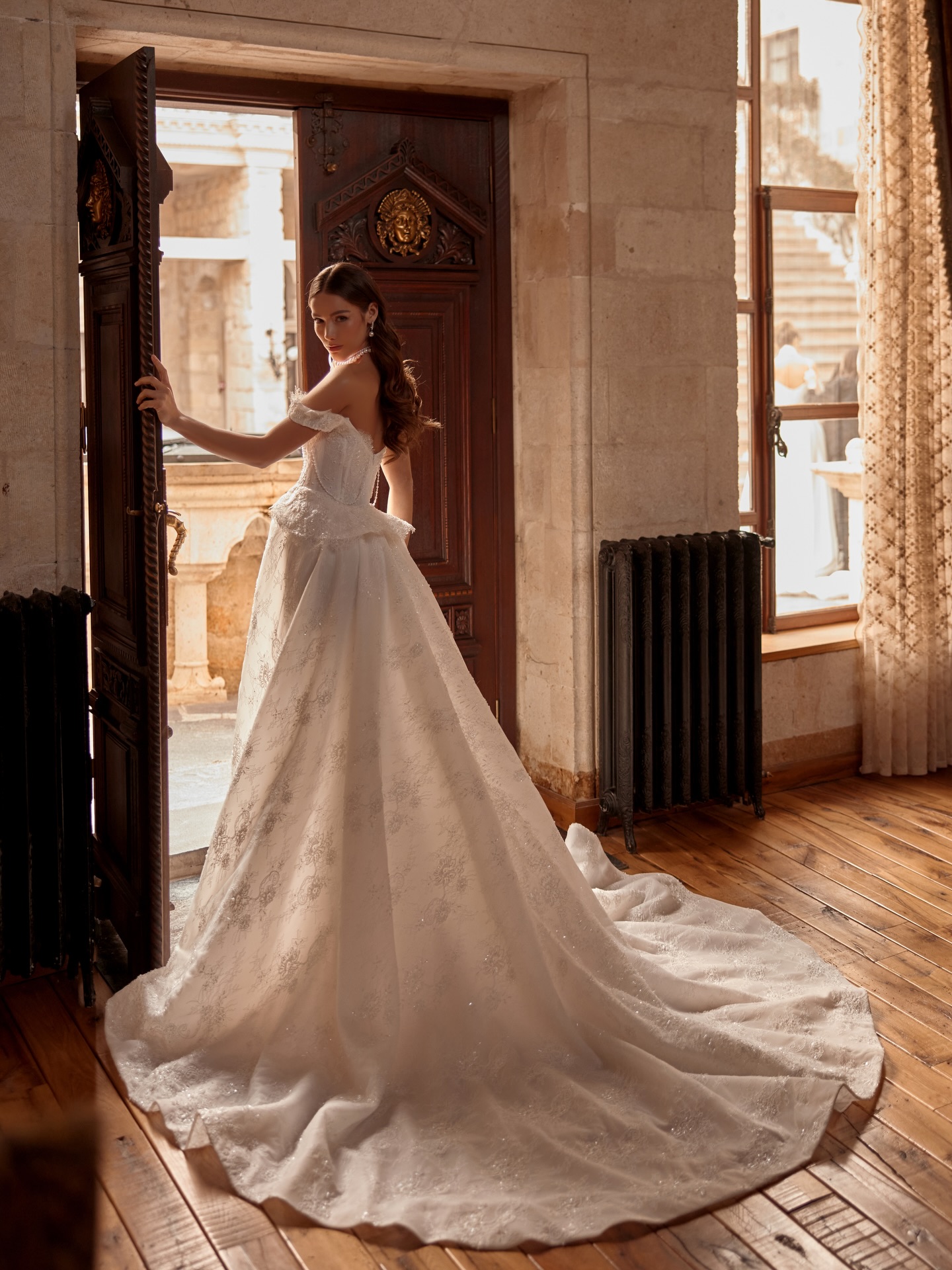 “Uzun kuyruklu balık gelinlik, tarihi dokulu mekânda geniş açı çekimde zarif ve ihtişamlı görünüm.”