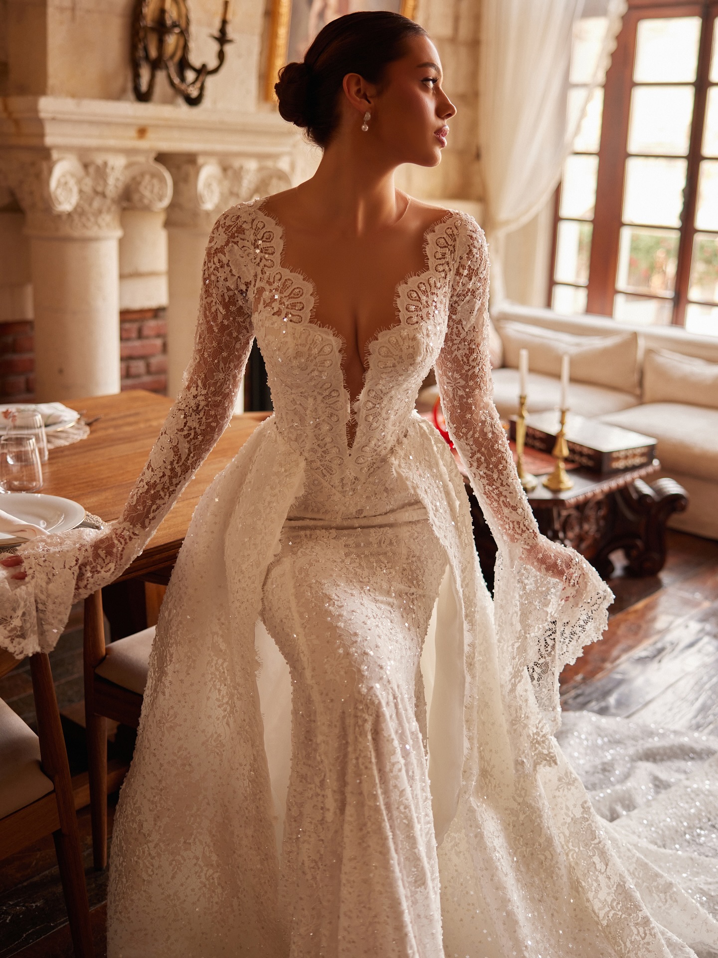 Dantel uzun kollu A kesim gelinlik, bel hattını vurgulayan modern kesim ve feminen V yaka detayıyla şık duruş.