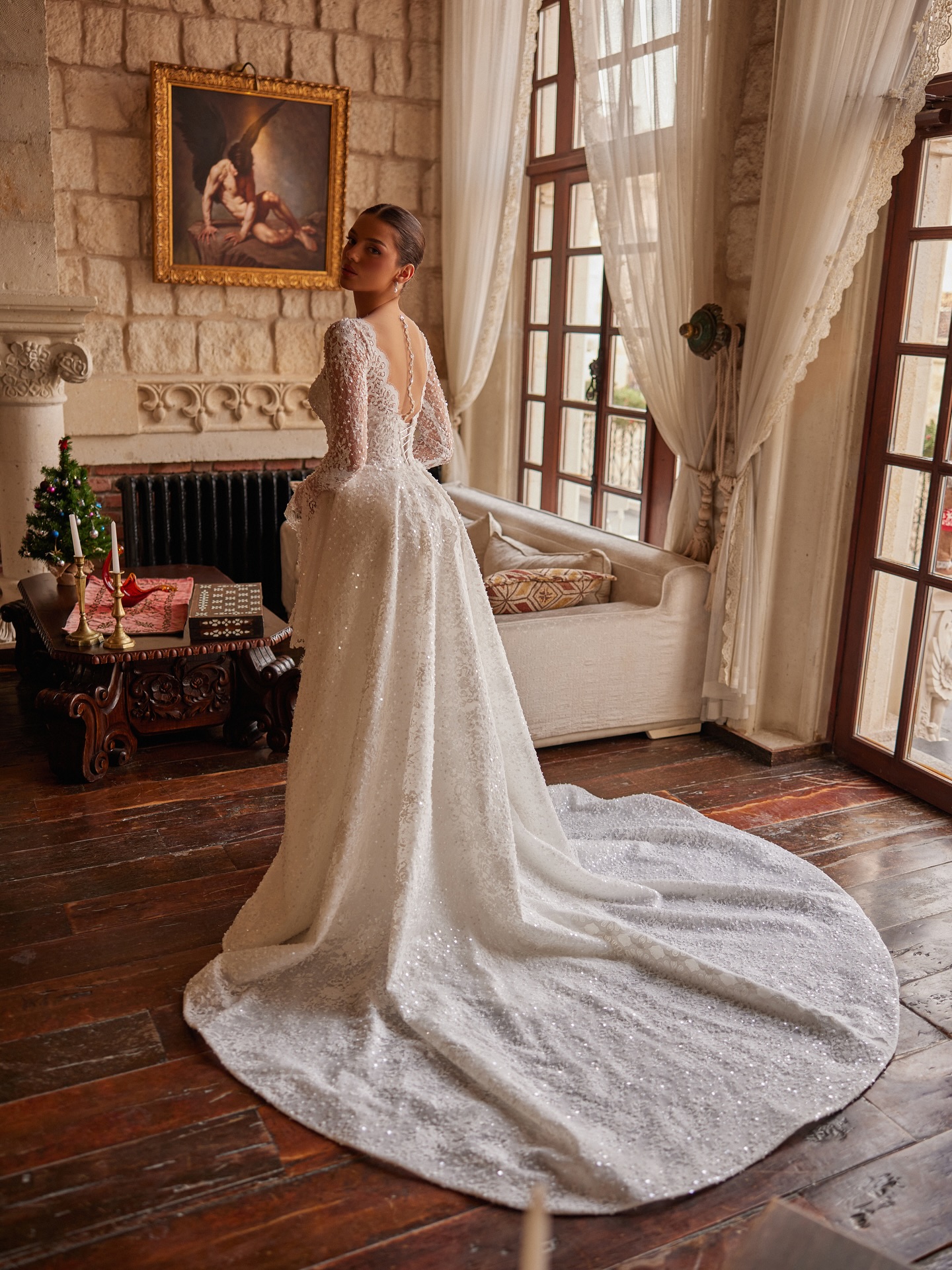 Arkadan görünümde kuyruklu dantel gelinlik modeli, zarif sırt detayı ve akışkan etek formuyla asil siluet.