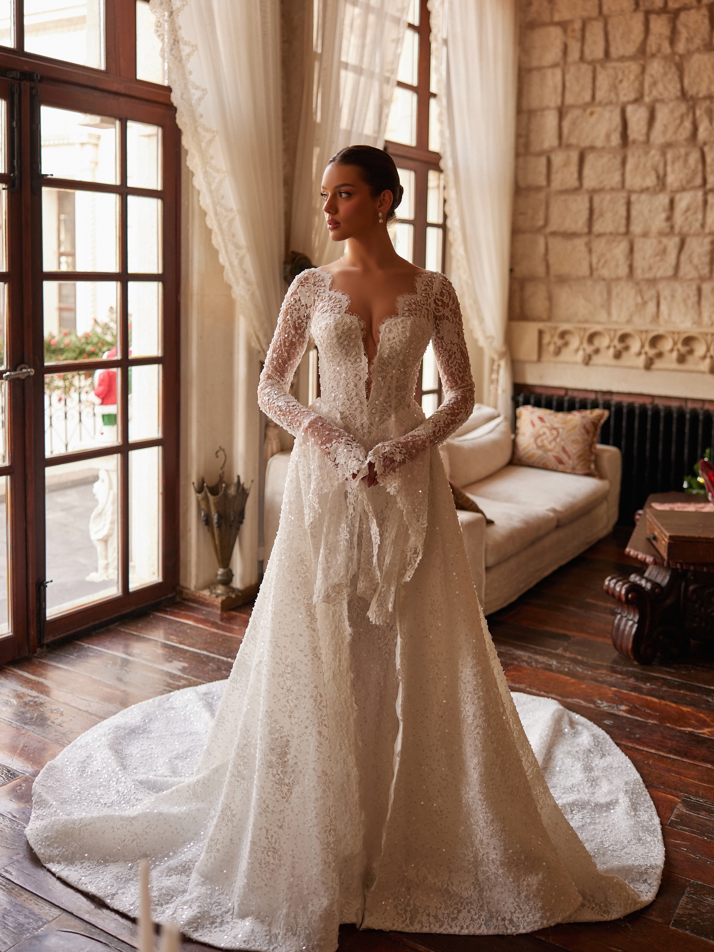 Tam boy çekimde kuyruklu dantel gelinlik, prenses geçişli A kesim siluet ve romantik dantel dokusu.