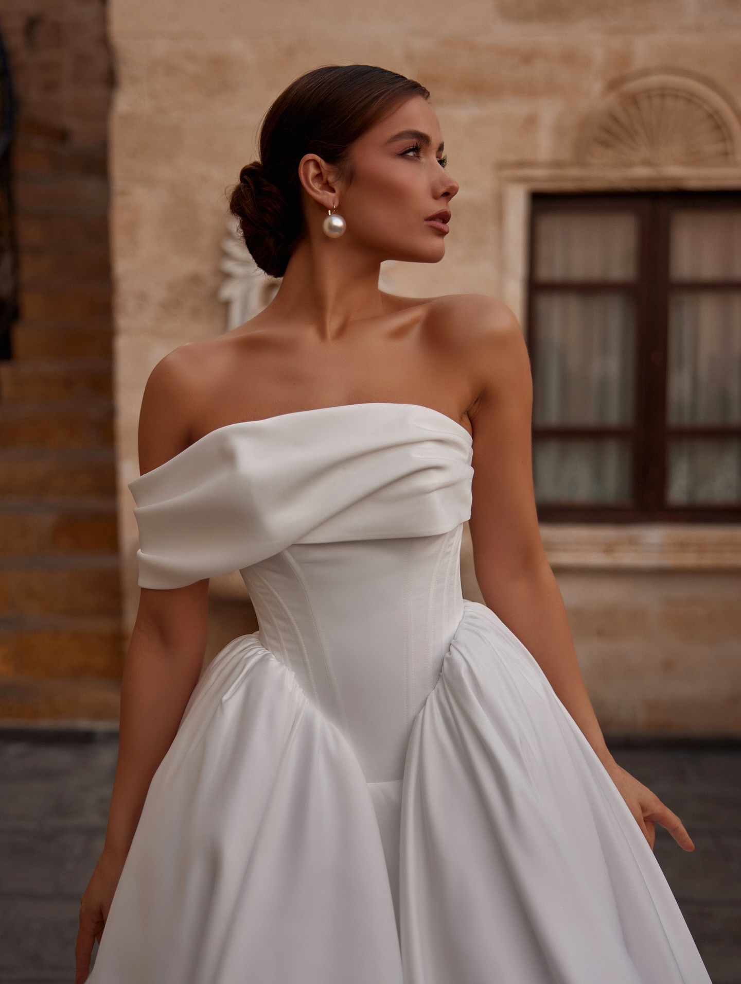  Minimal couture tarzda, straplez ve bel vurgulu Mediha Cambaz Bridal prenses gelinlik yan profil çekimi.