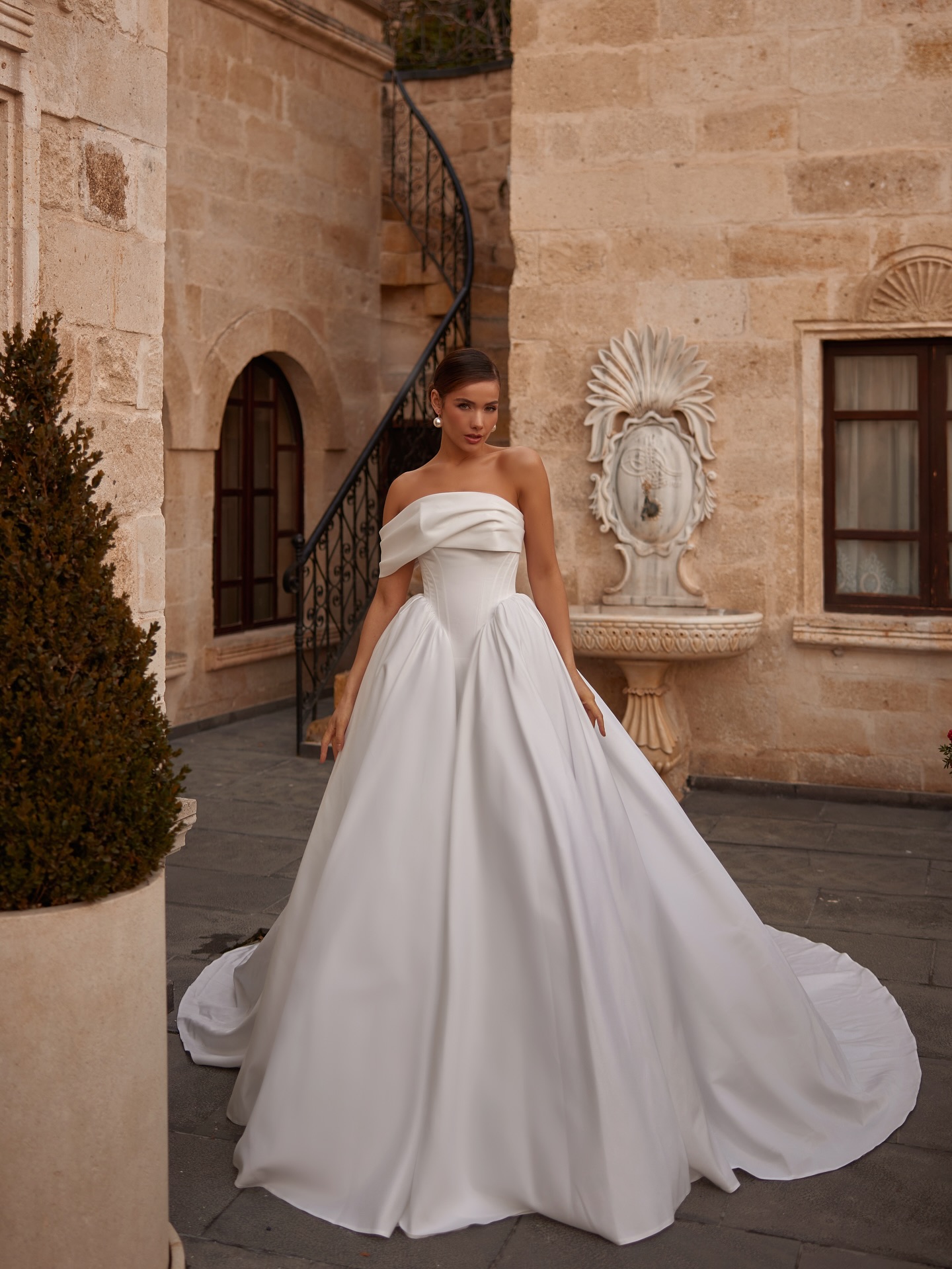 Uzun kuyruklu, tok kumaş dokulu ve zamansız tasarıma sahip Mediha Cambaz Bridal prenses gelinlik genel görünüm.