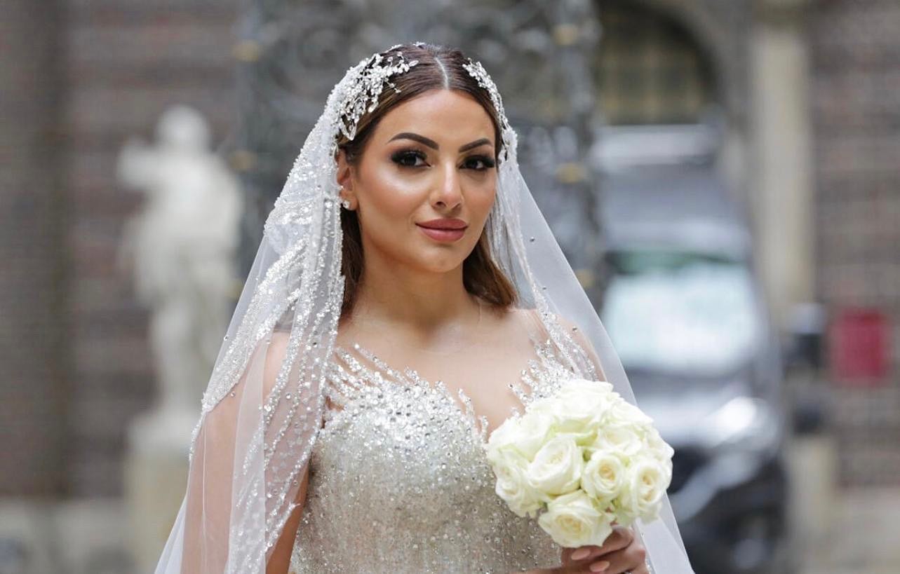 Işıltılı duvak ve taş işlemeli prenses gelinlik ile romantik gelin portresi, elde beyaz buket