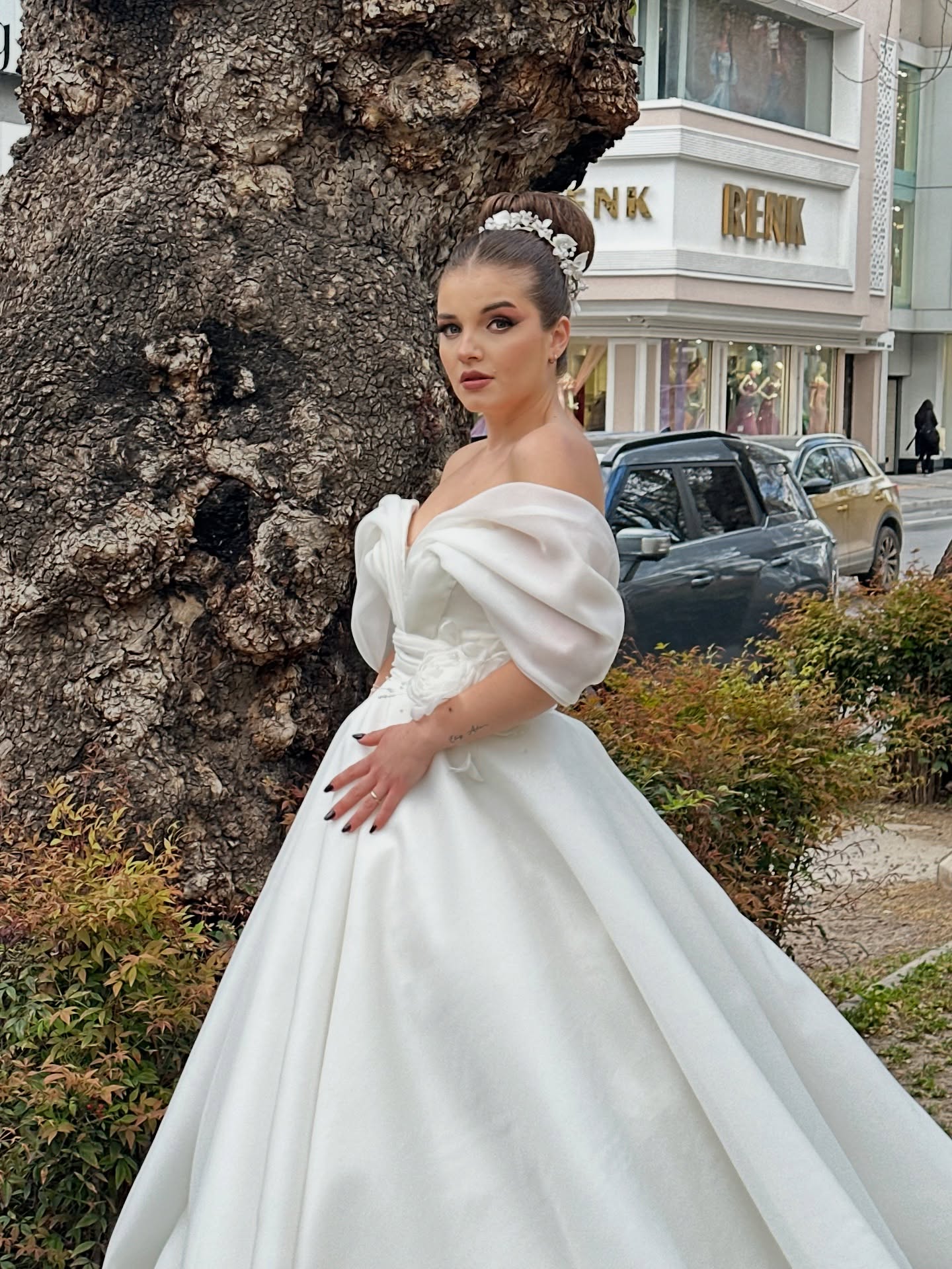 Yan profilden A kesim gelinlik – düşük omuz drape kol ve kabarık etek görünümü