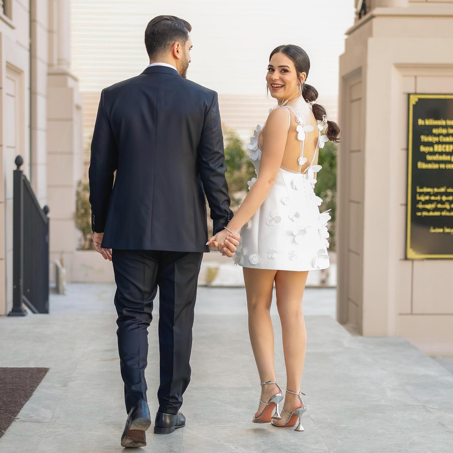 Özem Keskin mini gelinlik ile nikah konseptine uygun modern ve zarif çift çekimi, 3D çiçek detayları ön planda.