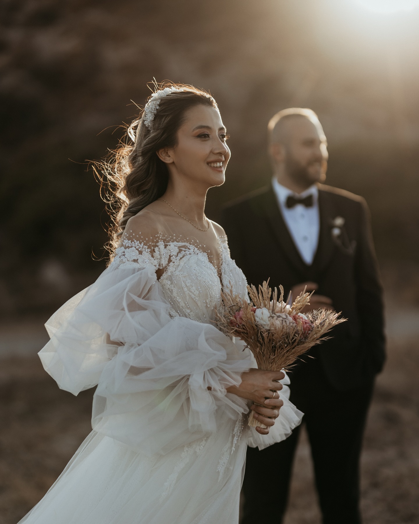 Gelin buketiyle gün batımında tül kollu A kesim gelinlik yakın plan portre çekimi