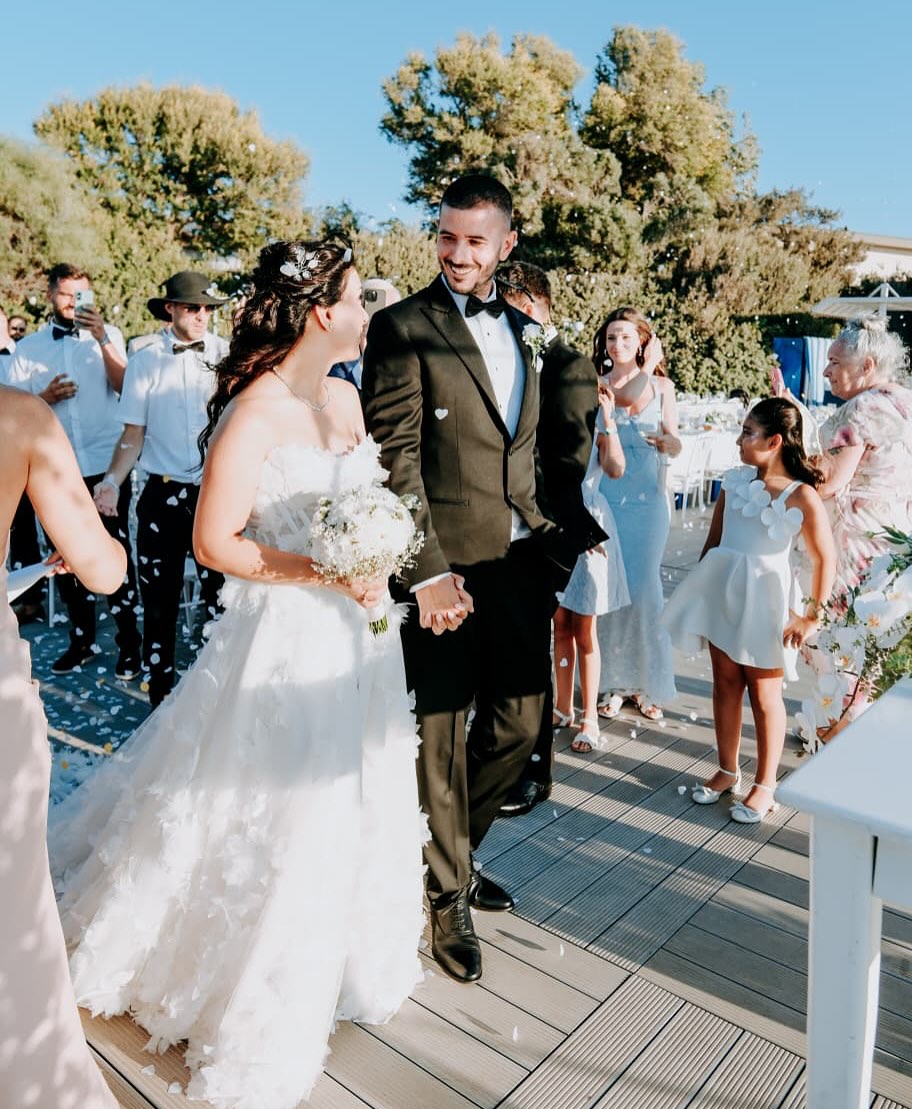 Düğün çıkışı konfeti altında straplez A kesim gelinlik ile yürüyen gelin ve damat