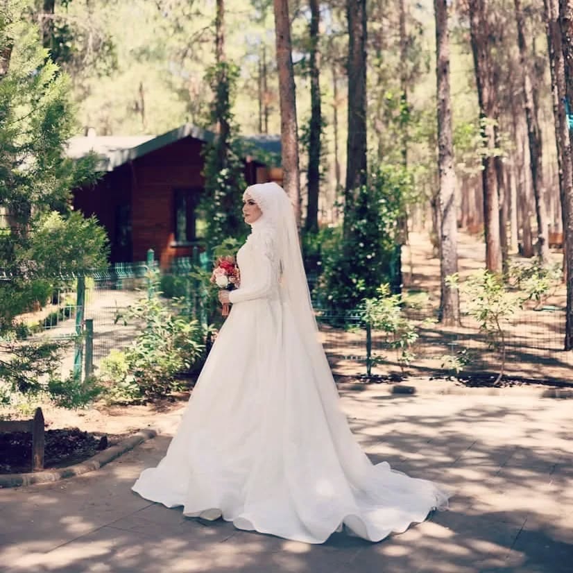 Uzun kollu sade saten gelinlik ile orman konseptinde gelin