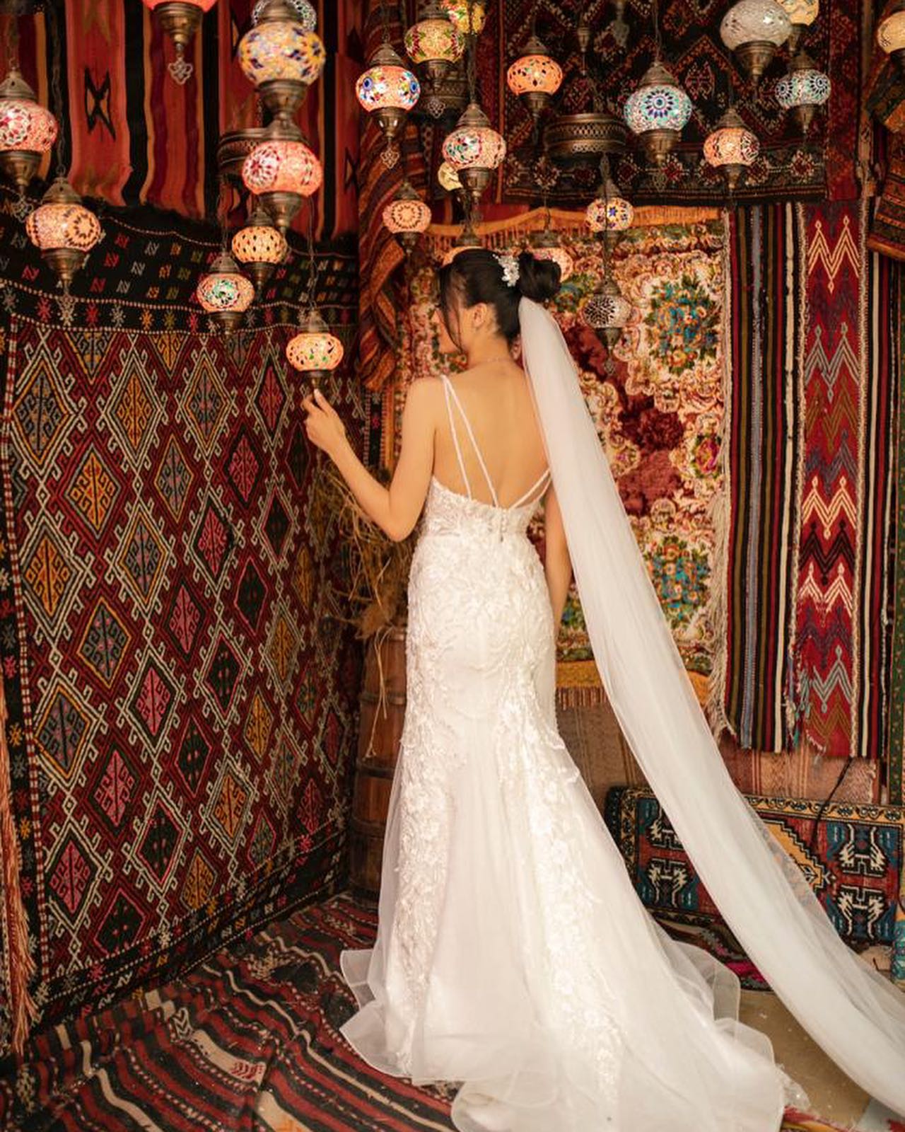 İnce askılı, dantel işlemeli dar kesim gelinlik ve uzun duvak – otantik desenli iç mekân