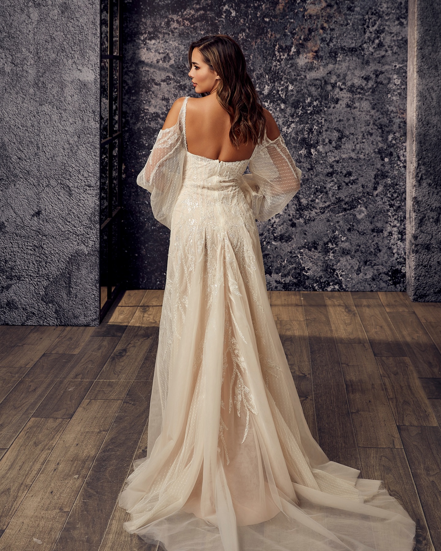 Uzun kuyruklu A kesim gelinlik arkadan görünüm, tül katmanlar ve ışıltılı aplikeler