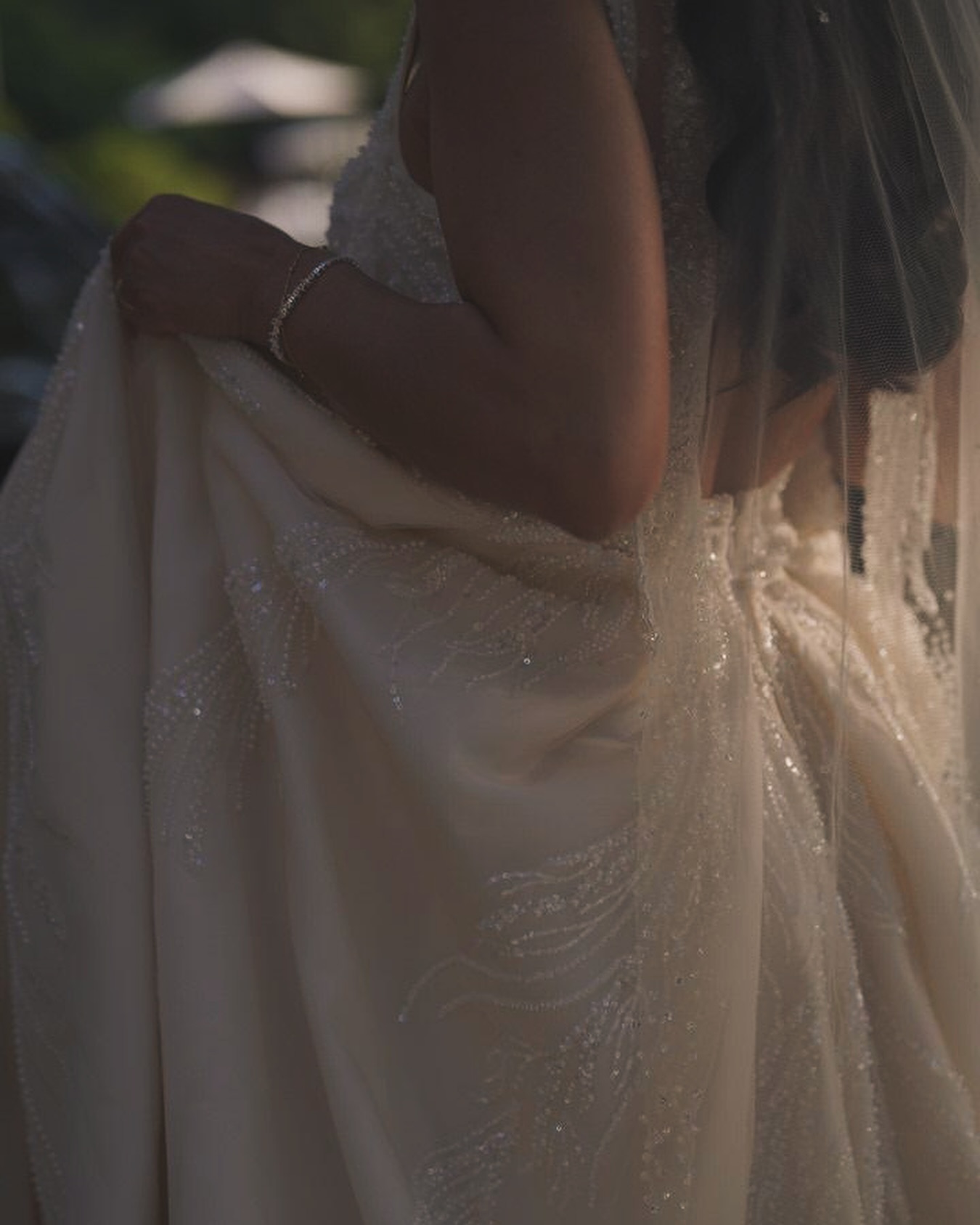 “Işıltılı işlemeli gelinlik kumaş detayı, yakın plan parlak doku ve zarif aksesuar görünümü.”